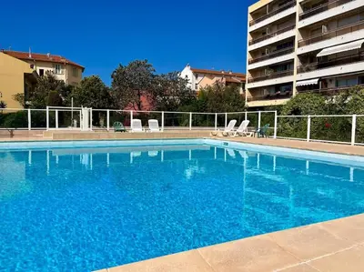 a large blue swimming pool next to a building at New apartment with swimming pool in Beaulieu-sur-Mer