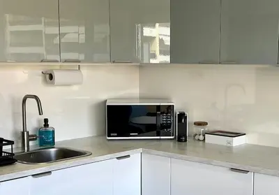 a microwave sitting on a kitchen counter next to a sink at New apartment with swimming pool in Beaulieu-sur-Mer