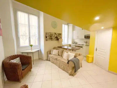 a living room with a couch and a kitchen at Charmant appartement atypique au coeur du Vieux-Nice in Nice