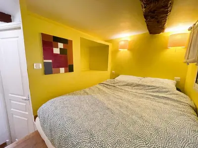 a yellow bedroom with a bed in a room at Charmant appartement atypique au coeur du Vieux-Nice in Nice