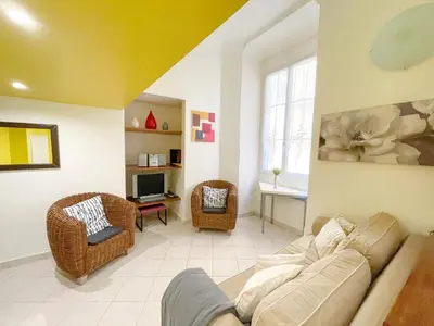 a living room with a couch and chairs and a tv at Charmant appartement atypique au coeur du Vieux-Nice in Nice