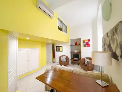 a living room with a couch and a table at Charmant appartement atypique au coeur du Vieux-Nice in Nice