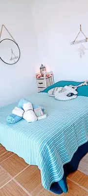 a large bed with a blue and white striped blanket at Chambre vue Nice & mer in Nice