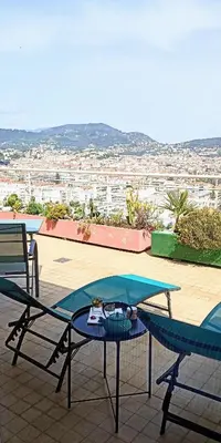 a table and chairs on a patio with a view at Chambre vue Nice & mer in Nice