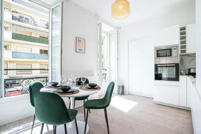a dining room with a table and green chairs at 06BZ - Modern apartment in the heart of the port in Nice