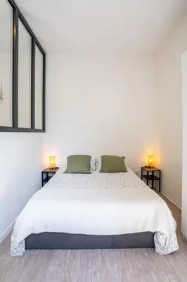 a white bedroom with a large bed and two lamps at 06BZ - Modern apartment in the heart of the port in Nice