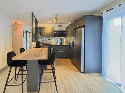 a kitchen with a wooden table and black appliances at Canta Galet - Wifi, AC, Parking, 4pers in Nice