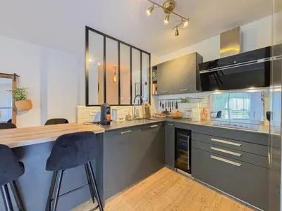 a kitchen with a counter and two bar stools at Canta Galet - Wifi, AC, Parking, 4pers in Nice