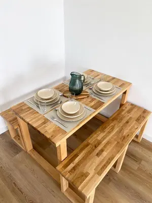 a wooden table with plates and a vase on it at Appartement - Proche plage & gare in Cagnes-sur-Mer