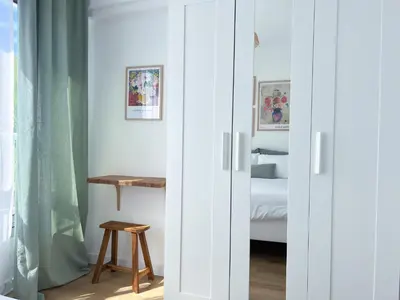 a bedroom with white doors with a bed and a table at Appartement - Proche plage & gare in Cagnes-sur-Mer