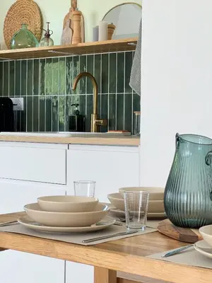 a kitchen table with plates and a sink at Appartement - Proche plage & gare in Cagnes-sur-Mer