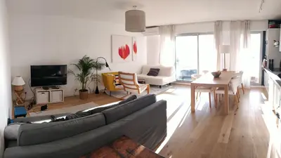 a living room with a couch and a table at Chez Gaël, vue mer, piscine, 3chb in Nice