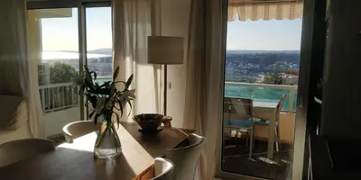 a room with a table and a large window at Chez Gaël, vue mer, piscine, 3chb in Nice
