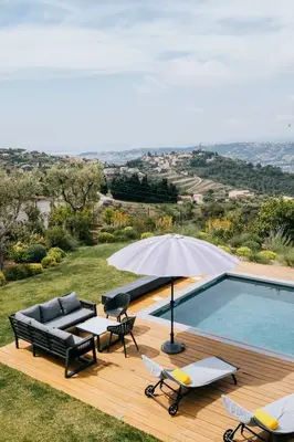 a patio with an umbrella and a swimming pool at Prestigieuse Villa De Crémat Nice in Nice