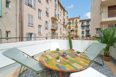 a table and chairs on a balcony with buildings at Nice Renting - BARBERIS - Unique Getaway 2-Room with Rooftop Terrace in Nice