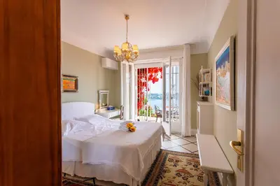 a bedroom with a white bed and a window at ROMANTIC VILLA VI4412 By Riviera Holiday Homes in Villefranche-sur-Mer