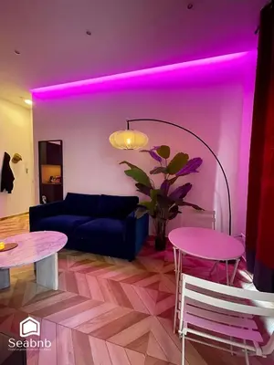 a living room with purple lighting and a couch and tables at Luxurious Apartment - Seaside - Spa Bath - WiFi - AC in Nice