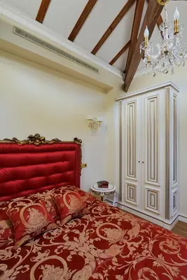 a bedroom with a large red bed with a chandelier at Maison des Barons in Nice