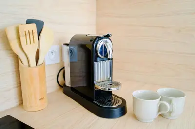 a coffee maker sitting next to two cups on a table at Charming 23 m studio near the sea in Nice
