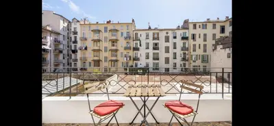 two chairs and a table on a balcony with buildings at Studio de luxe au cœur de Nice in Nice