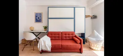 a red couch in a living room with a table at Studio de luxe au cœur de Nice in Nice