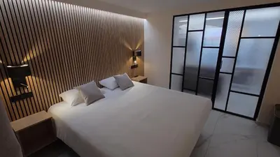 a bedroom with a white bed and a large window at Club Inn Appartement in Nice