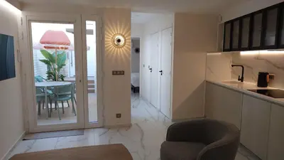 a kitchen and dining room with a table and a chair at Club Inn Appartement in Nice