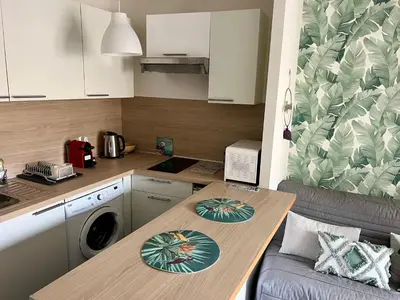 a small kitchen with a table with a washing machine at Palm Leaf Studio Nice in Nice