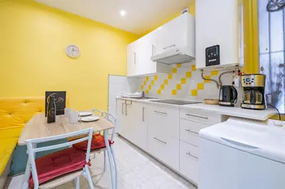 a kitchen with white cabinets and a small table at 2P hyper-centre Nice in Nice