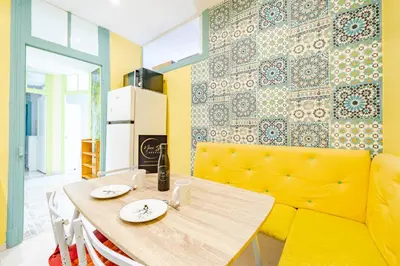a dining room with a table and a yellow couch at 2P hyper-centre Nice in Nice