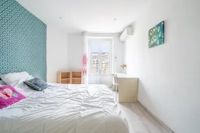 a bedroom with a white bed and a green wall at 2P hyper-centre Nice in Nice