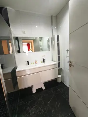 a white bathroom with a sink and a mirror at LE MIOLLIS - CENTRAL et CONFORT - WIFI- prés tansports en commun et commerces in Nice