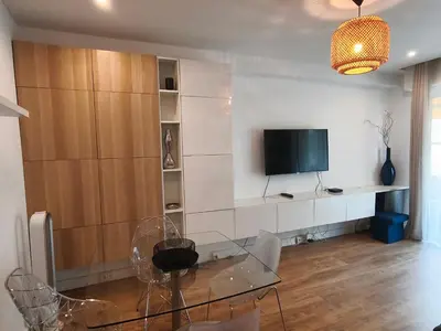 a living room with a glass table and a television at LE MIOLLIS - CENTRAL et CONFORT - WIFI- prés tansports en commun et commerces in Nice