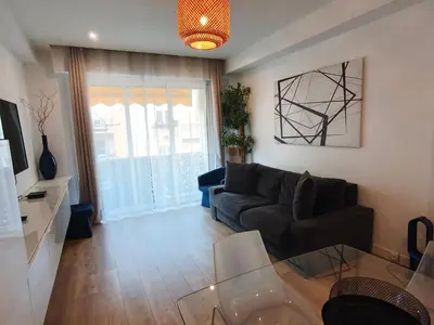 a living room with a couch and a glass table at LE MIOLLIS - CENTRAL et CONFORT - WIFI- prés tansports en commun et commerces in Nice