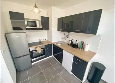 a small kitchen with a refrigerator and a microwave at Studio cosy près du port in Nice
