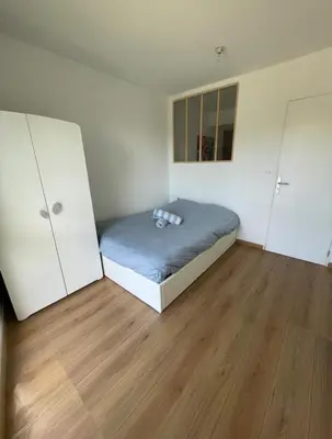a small bedroom with a bed and two closets at Appartement avec piscine in Saint-Laurent-du-Var