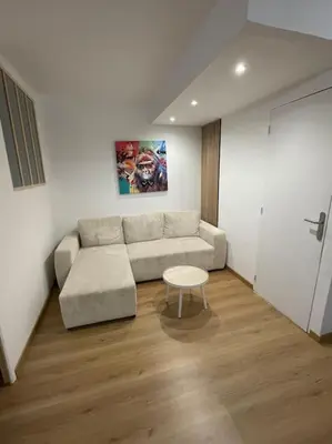 a living room with a couch and a table at Appartement avec piscine in Saint-Laurent-du-Var
