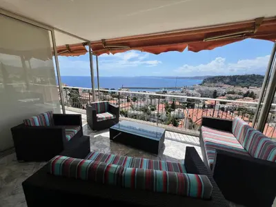a balcony with couches and a view of the ocean at ApartHotel Riviera - TERRASSE DES AGAVES - Amazing Sea View Nice Côte d'Azur in Nice
