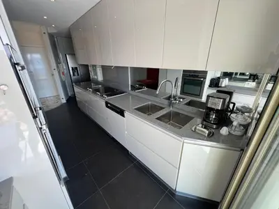 a kitchen with white cabinets and a sink at ApartHotel Riviera - TERRASSE DES AGAVES - Amazing Sea View Nice Côte d'Azur in Nice