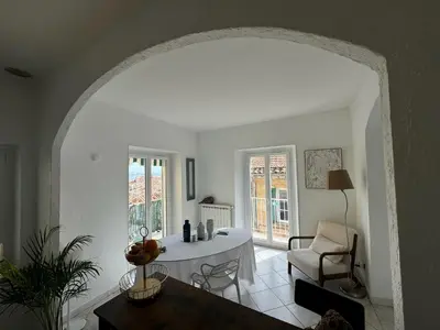 a living room with a table and a chair at The Seaside Serenity -NEW AC equipped - Calm with Bay View - Heart of Villefranche in Villefranche-sur-Mer