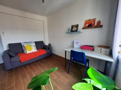a living room with a couch and a table at La chambre 2, Climatisée AC, Calme, Cuisine privée in Nice