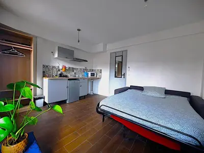 a bedroom with a bed and a kitchen at La chambre 2, Climatisée AC, Calme, Cuisine privée in Nice