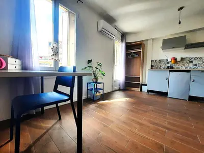 a kitchen with a table and a blue chair in a room at La chambre 2, Climatisée AC, Calme, Cuisine privée in Nice