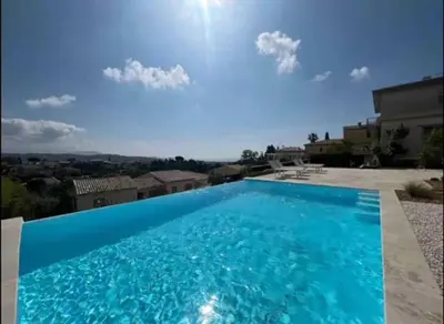 a large blue swimming pool in front of a house at DOMAINE LOU BEL AZUR - Harmonie in Saint-Laurent-du-Var