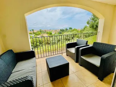 a balcony with two chairs and a couch and a window at DOMAINE LOU BEL AZUR - Harmonie in Saint-Laurent-du-Var