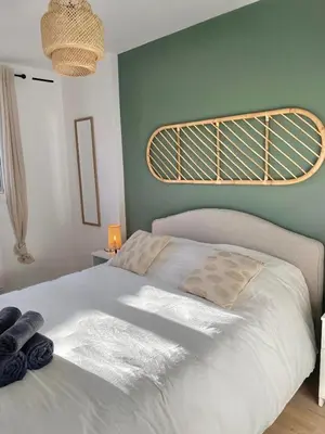 a bedroom with a white bed with a green wall at Modern & Cosy 3 Bedrooms train tramway in Nice