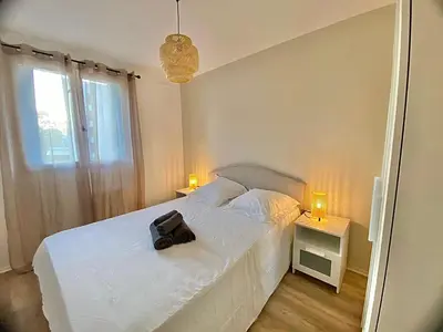 a bedroom with a white bed with a black bag on it at Modern & Cosy 3 Bedrooms train tramway in Nice
