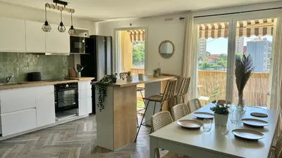 a kitchen and dining room with a table and chairs at Modern & Cosy 3 Bedrooms train tramway in Nice