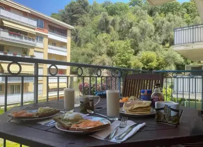 a table with plates of food on a balcony at Happy place in Nice