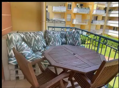 a couch and a wooden table on a balcony at Happy place in Nice